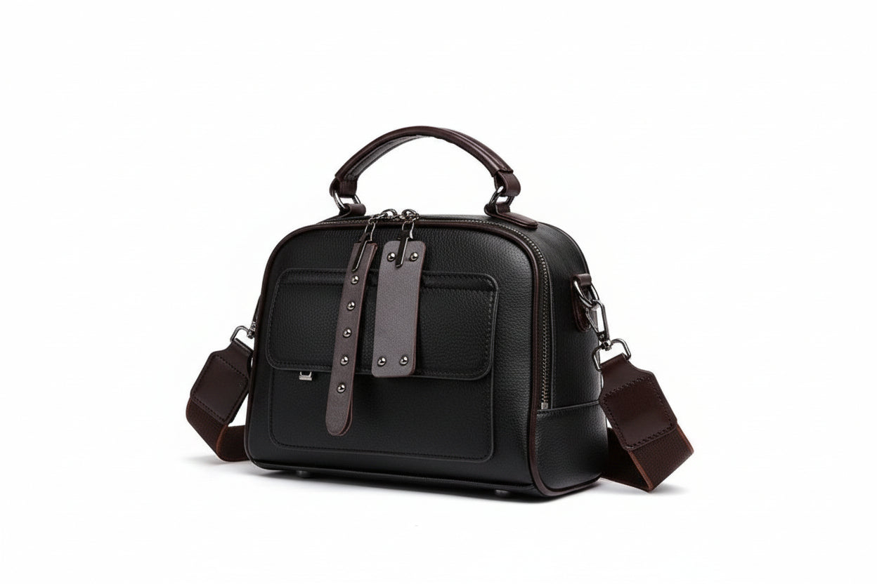 Black handbag with brown strap on a beige background