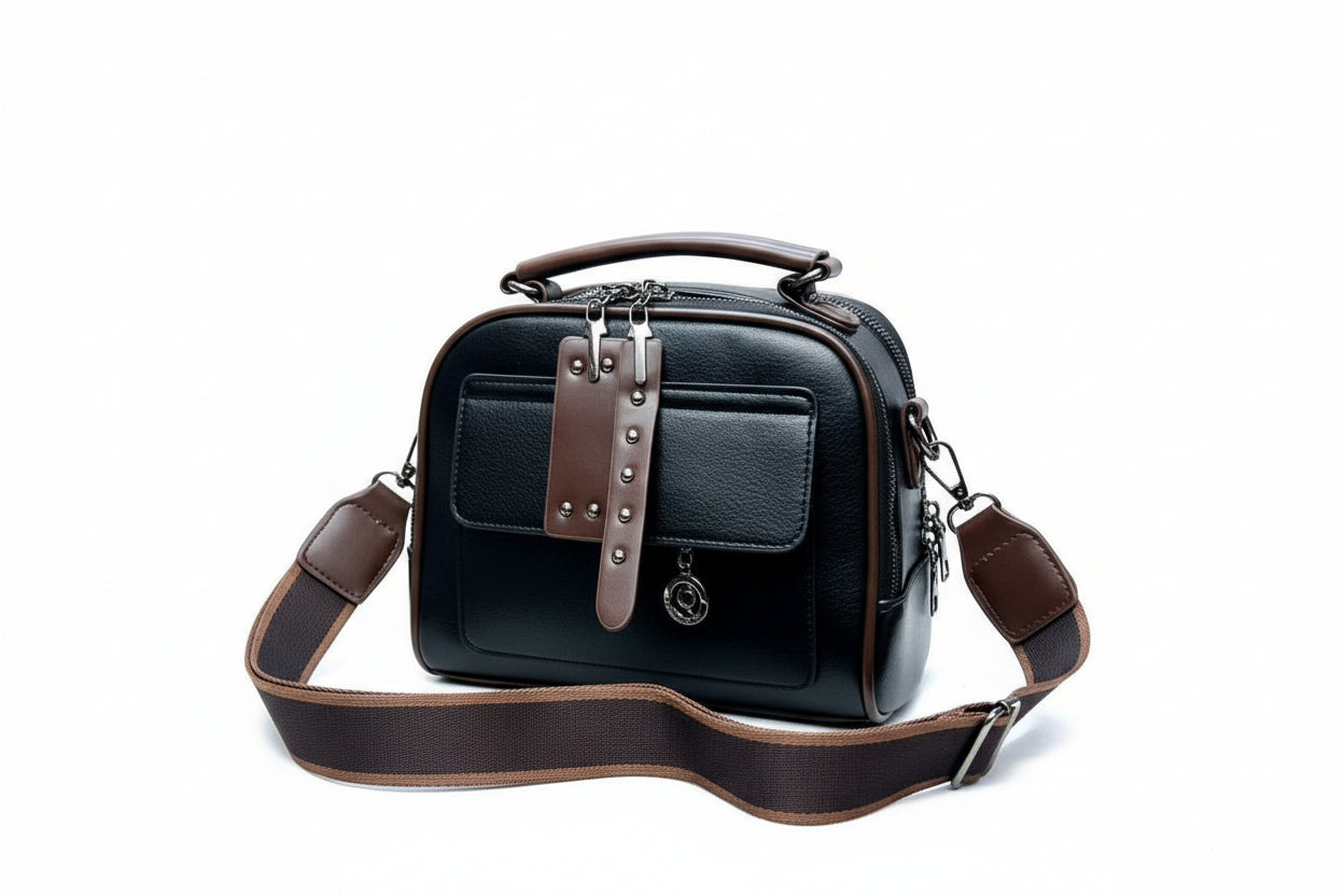 Black handbag with brown straps on a white surface