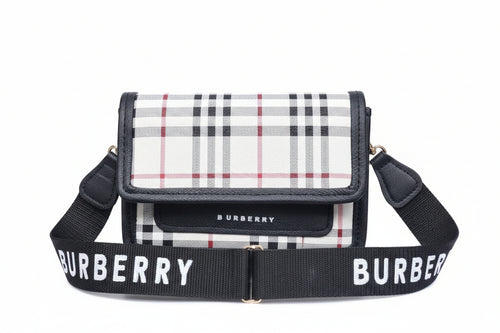 Burberry handbag with plaid pattern and matching strap on a striped background