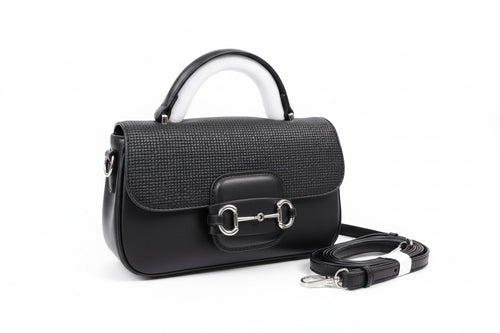 Black handbag with a strap on a brown box, with 'Burberry' branding.